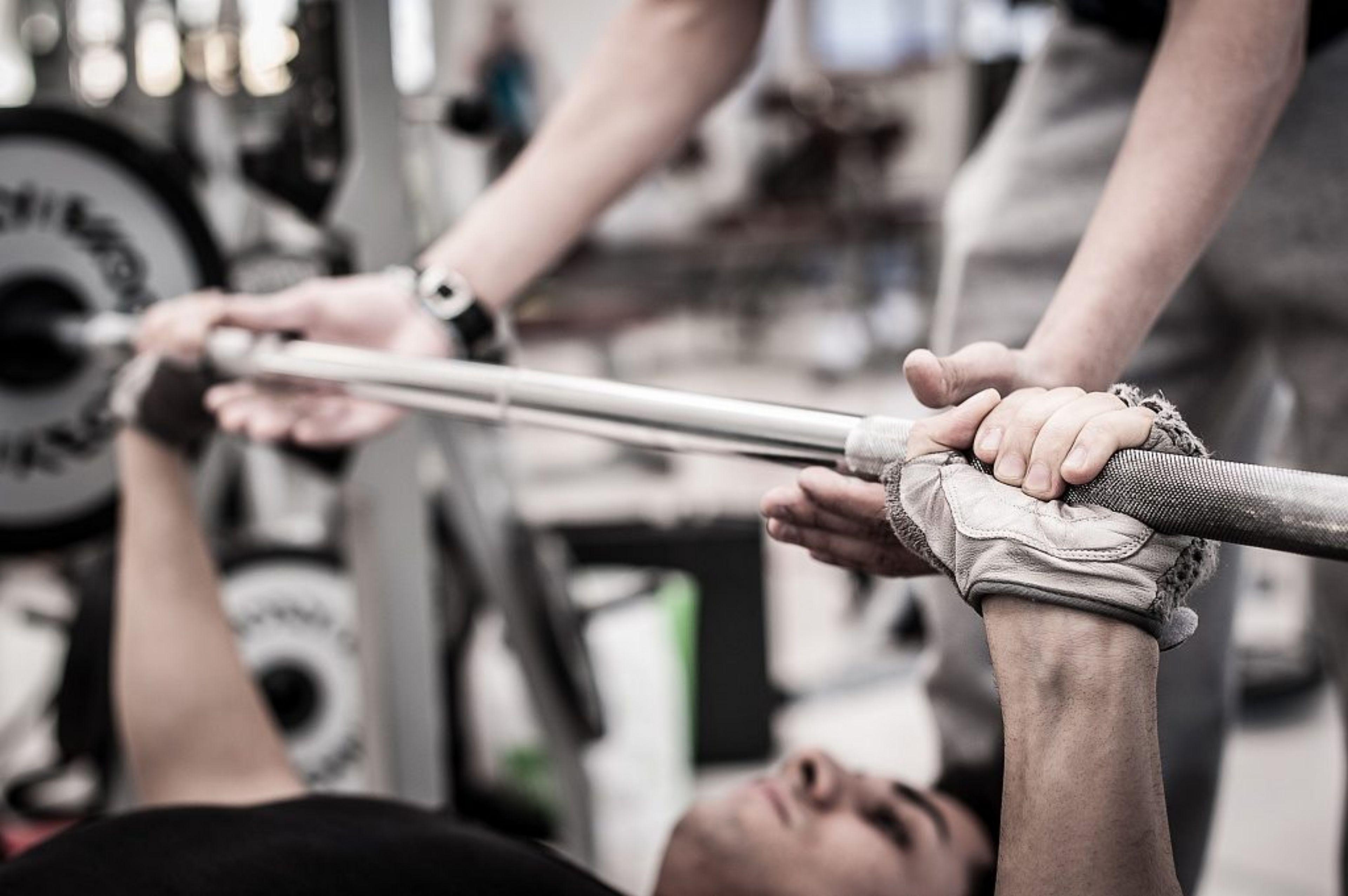 Person bench pressing with a spotter